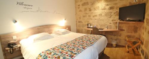 a bedroom with a bed and a desk and a television at Best Western Le Pont d'Or in Figeac