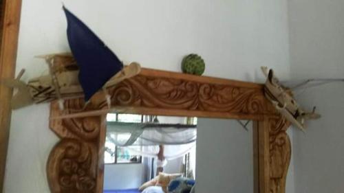 a mirror with a wooden frame and a mirror with a reflection of a mirror at Mango Lodge MSAMBWENI in Kisimachande