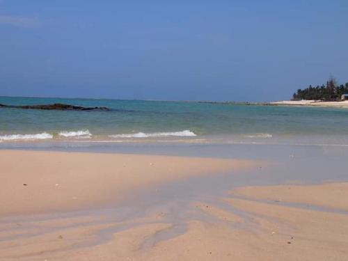a sandy beach with the ocean in the background at Mango Lodge MSAMBWENI in Kisimachande