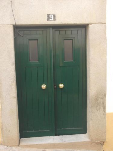 a green door in the side of a building at Casa da Avó in Castelo de Vide