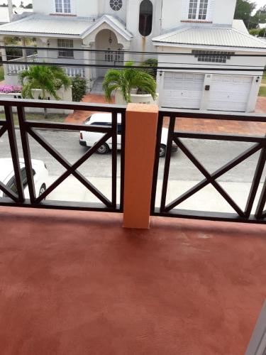 a table on a balcony with a view of a house at Manderley Villas in Saint Philip