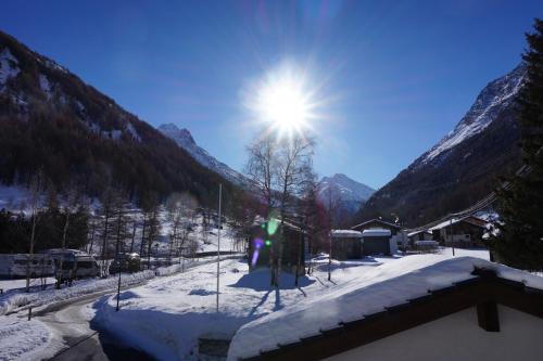 a sun shining over a snow covered mountain at Art Oase - Lenzspitze in Saas-Grund
