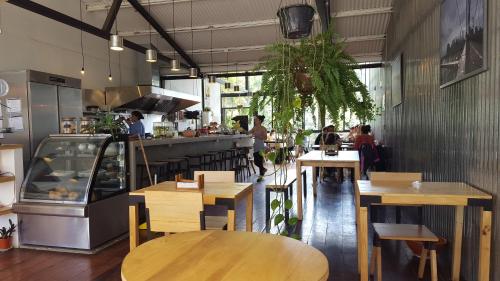 a restaurant with wooden tables and people in the kitchen at OutBox Inn in Monteverde Costa Rica