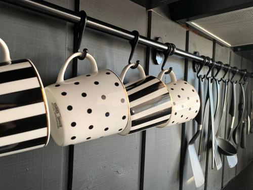 a bunch of utensils are hanging on a rack at HARMONY Design and Vacation House in Bigauņciems
