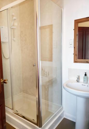 a bathroom with a shower and a sink at Jolly Sailor Inn - THE OLDEST PUB IN LOOE - Family run and full of charm and character in Looe