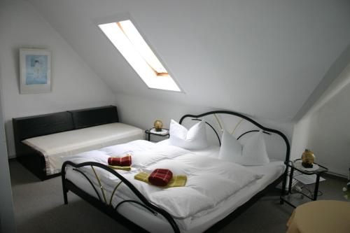 Schlafzimmer mit einem Bett mit weißer Bettwäsche und Kissen in der Unterkunft Pension Bodetal in Elend