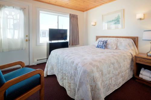 a bedroom with a bed and a tv and a window at Alouette Beach Resort Economy Rooms in Old Orchard Beach