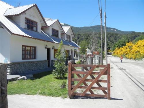 una casa con una puerta de madera junto a una calle en Cabaña Sol del Bayo en Villa La Angostura