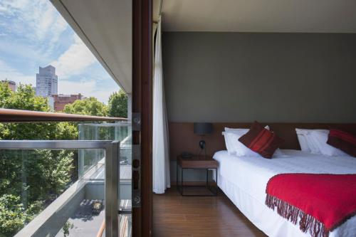 a bedroom with a bed and a large window at Palermo Soho Square in Buenos Aires