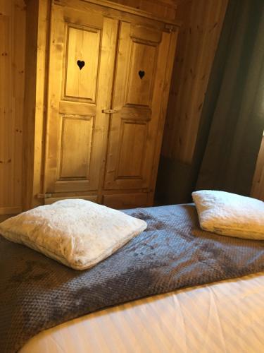 two pillows sitting on a bed in a room at Clos Shambhala-Chalet d'hôtes in Saint-Jean-Saint-Nicolas