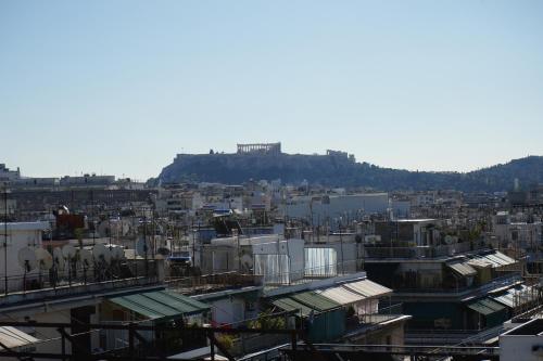 a city with buildings and a hill in the background at Socrates Hotel in Athens
