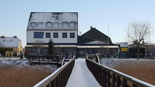 a bridge leading to a white building with a roof at Avila Park & SPA in Dziwnówek