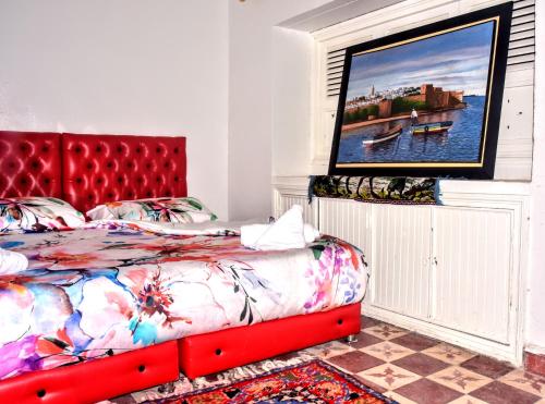 a bedroom with a bed with a red headboard at Riad Razoli Sidi Daoui in Rabat