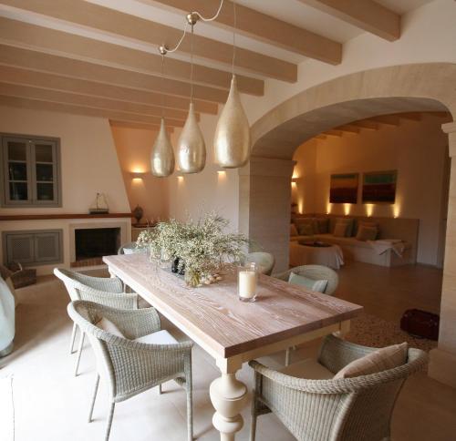a dining room with a wooden table and chairs at Living Casa Luna in Santanyi