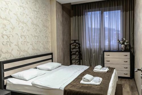 a bedroom with a bed and a dresser and a window at TB Apart-Hotel in Tbilisi 1 in Tbilisi City
