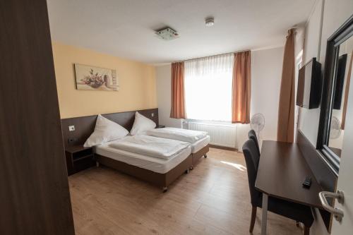 a hotel room with a bed and a window at Schnitzelhaus und Pension Stadt Rosbach in Rosbach vor der Höhe