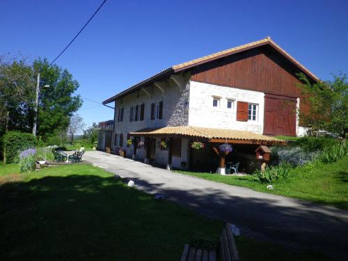 a large white building with a red door in a yard at Chambre d'hôtes La Haie Fleurie in Chevillard