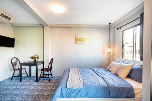 a bedroom with a bed and a table and chairs at Penyos Suite in Bangkok
