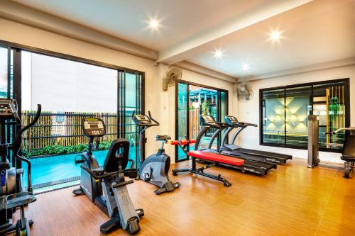 a gym with treadmills and exercise equipment in a room at Penyos Suite in Bangkok