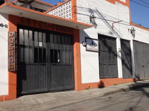 an orange and white building with two doors at Hotel Posada El Gran Cipres in San Cristóbal de Las Casas