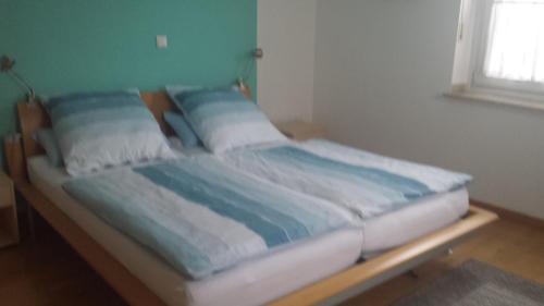 Una cama con sábanas y almohadas azules y blancas. en Ferienwohnung Pöttershof, en Krefeld