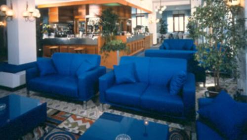 a lobby with blue couches and a bar at Hotel Majestic in Pesaro