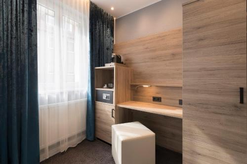a bathroom with a toilet and a window at Hotel dasPaul in Nuremberg