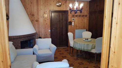 a living room with a table and chairs and a fireplace at Casa Nilù in Rivisondoli