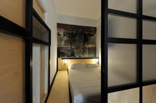 アテネにあるLiving modern in the centre of historyのベッドと窓が備わる小さな客室です。