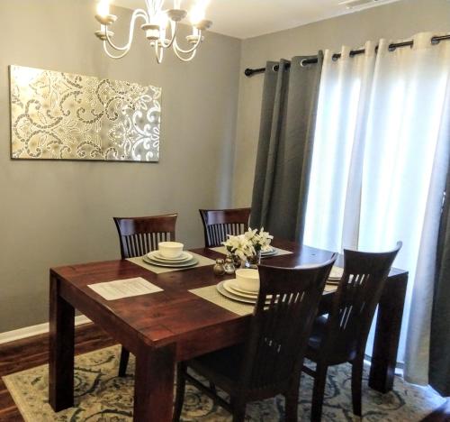 a dining room with a wooden table and chairs at Delightful Townhome - Central Raleigh Location in Raleigh
