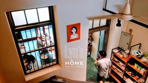 a man standing in a room with a poster on the wall at Yu Cafe Hostel in Songkhla
