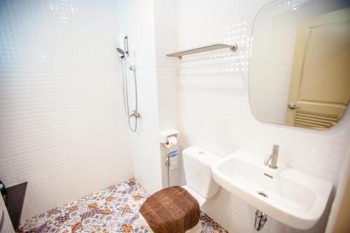 Baño blanco con lavabo y espejo en iRabbit Hotel en Prachin Buri