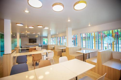 a cafeteria with tables and chairs and stained glass windows at iRabbit Hotel in Prachin Buri