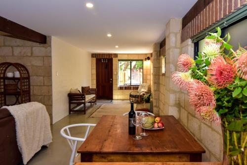 a living room with a table with a bottle of wine at By the Sea Margaret River in Gnarabup