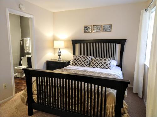 a bedroom with a large bed with a black headboard at Delightful Townhome - Central Raleigh Location in Raleigh