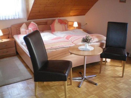 1 Schlafzimmer mit einem Bett, 2 Stühlen und einem Tisch in der Unterkunft Mosel-Gästehaus Kirch in Ernst