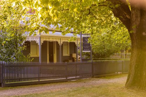 une vieille maison avec une clôture et un arbre dans l'établissement Belmont at Beechworth 2 bedrooms, 2 bathrooms, 2 couples, à Beechworth