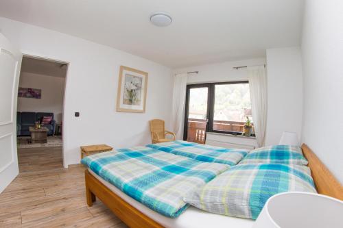 ein Schlafzimmer mit einem Bett mit einer karierten Decke in der Unterkunft Ferienwohnung am Sulzbach in EuÃŸerthal