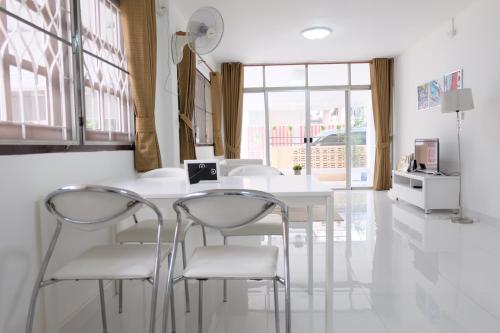 a white dining room with a white table and chairs at Chatuchak Art & Nature House ( 3-6 pers.) in Bangkok
