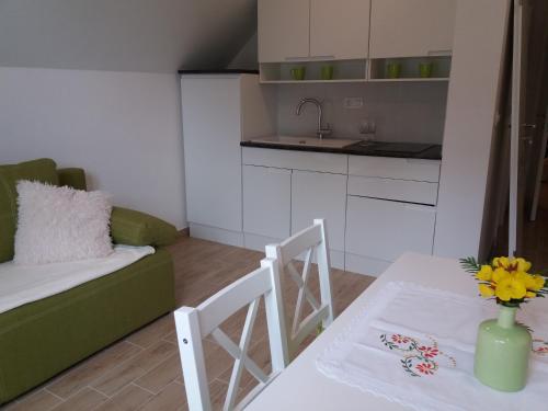 a small living room with a table and a kitchen at Apartma Momo in Bohinj