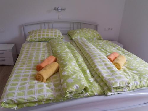 a bed with pillows and comforters on it at Apartma Momo in Bohinj