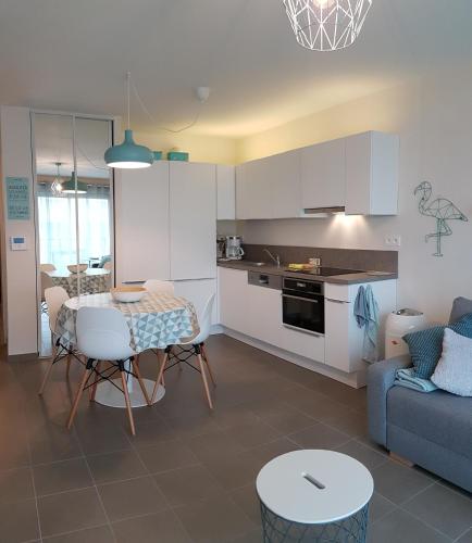 une cuisine et un salon avec une table et un canapé dans l'établissement Belopale @ Résidence La Belle Epoque, à Wimereux
