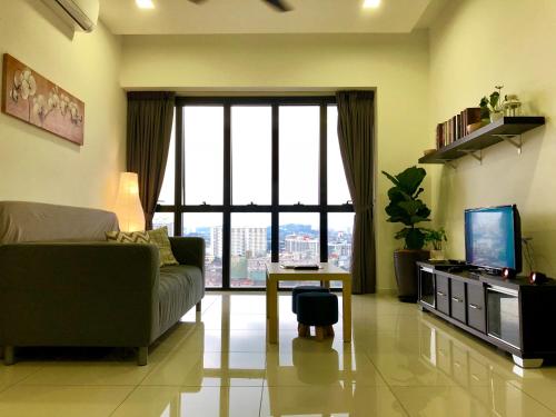 a living room with a couch and a large window at CoZy Suite @ PJ & Sunway(2 Bedroom) in Petaling Jaya