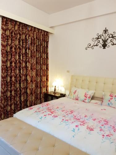 a bedroom with a large white bed with flowers on it at Jhen Pin Xuan B&B in Taitung City