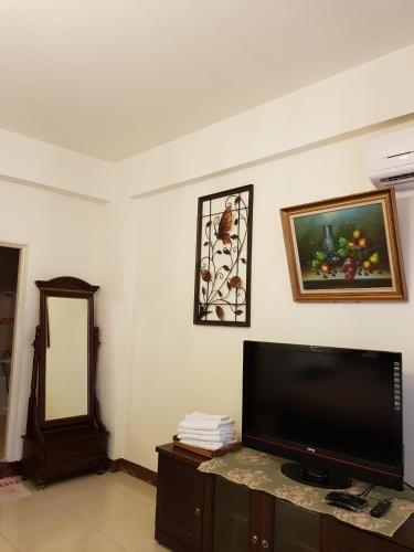 a living room with a flat screen tv and a mirror at Jhen Pin Xuan B&B in Taitung City