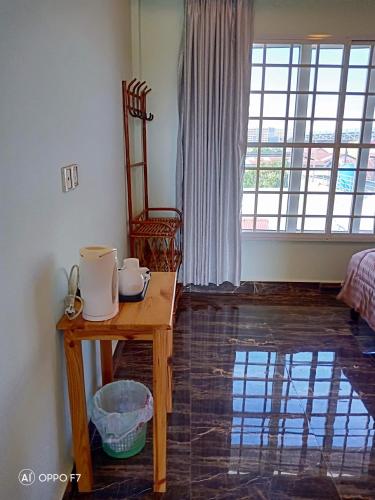 a room with a table and a chair and a window at KOL House in Phnom Penh