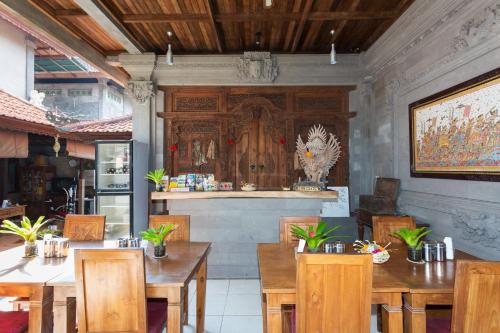 Un restaurante con mesas y sillas de madera y un mostrador. en Bali Moon Guest House, en Ubud