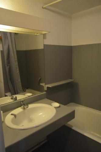 La salle de bains est pourvue d'un lavabo, d'un miroir et d'une baignoire. dans l'établissement Studio A, à Hyères