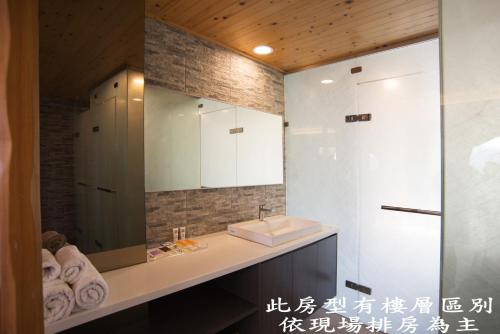 een badkamer met een wastafel en een spiegel bij Tang Zhimei Hot Spring in Taian