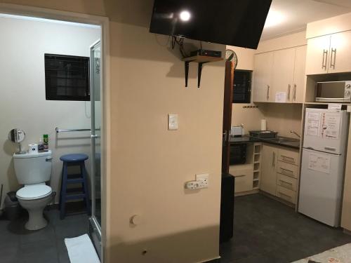 a small kitchen with a toilet and a sink at A Little Guesthouse in Bloemfontein